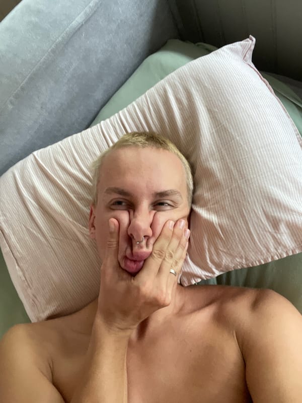 Person makes playful faces while resting on pillow in Sestroretsk