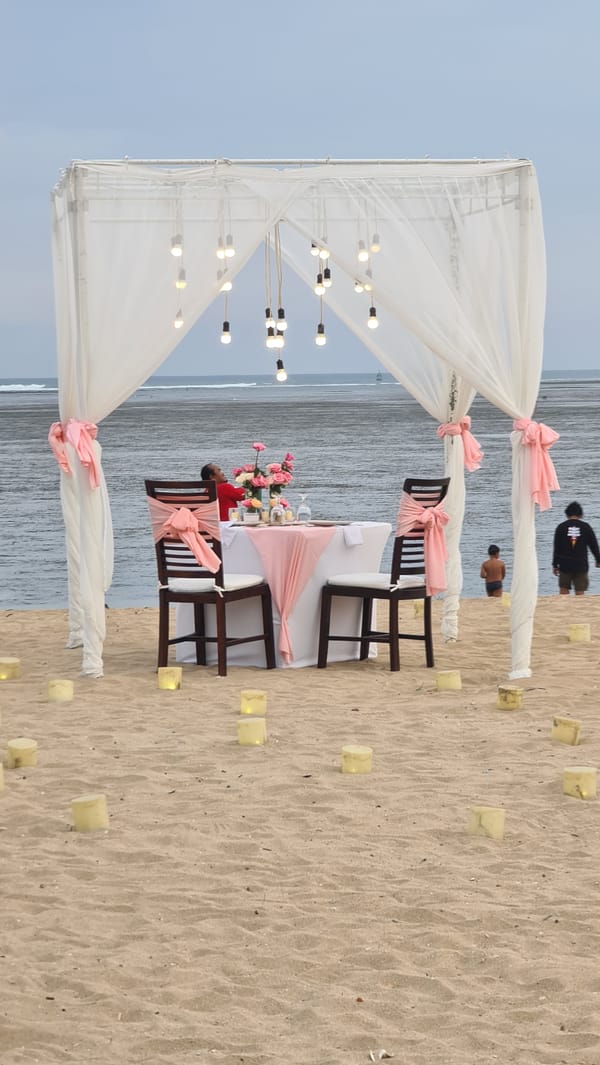 Quiet morning on a Denpasar beach: dining setups, boats, and joggers