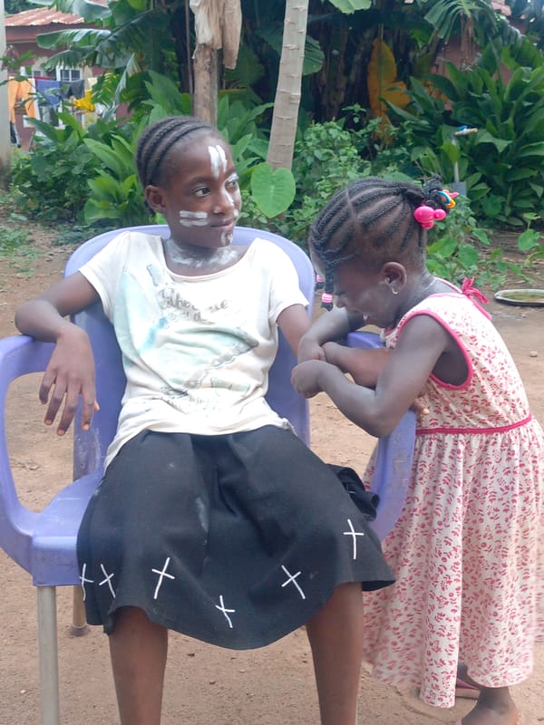 Kids in face paint dance at a laid-back Akwanga gathering