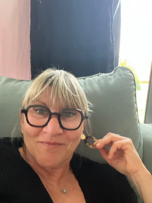 Woman displays tortoiseshell earrings indoors in Chambœuf