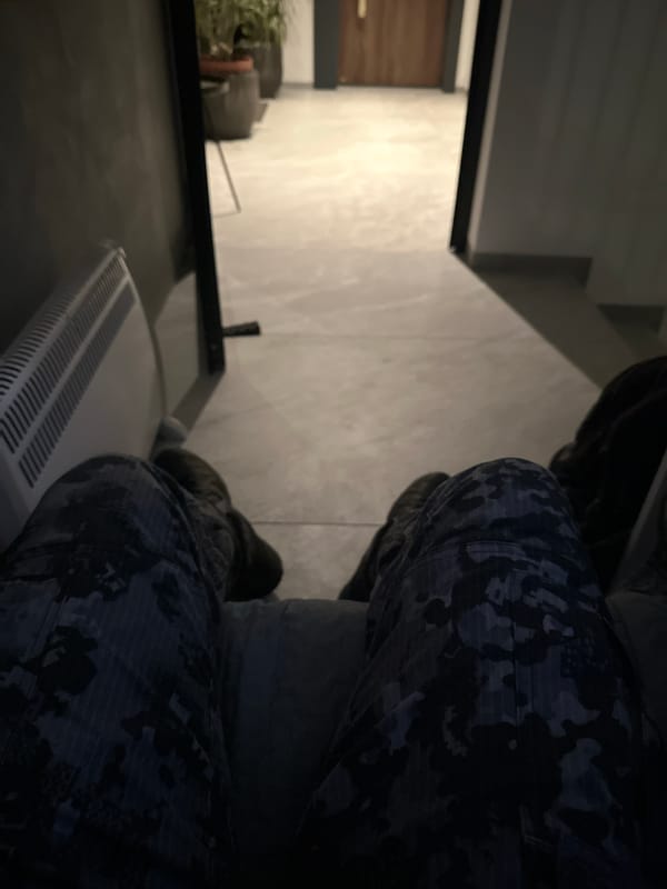Person in camouflage sits on radiator in Sofia interior