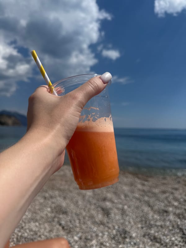 Beachgoers enjoy colorful drinks during sunny afternoon in Montenegro