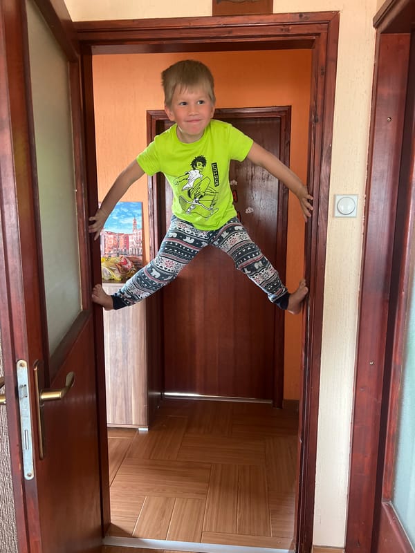 Boy performs handstand in doorway in Podgorica