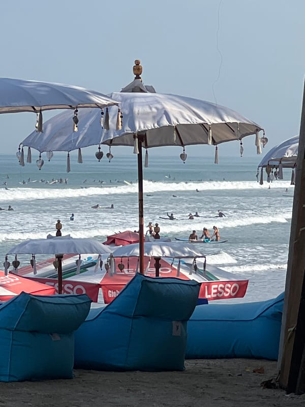 Busy morning session at Kuta Beach, surfers and crowds in the mix