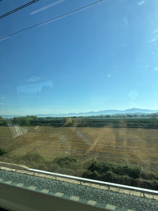 Train passenger photographs mountain landscape near Rome