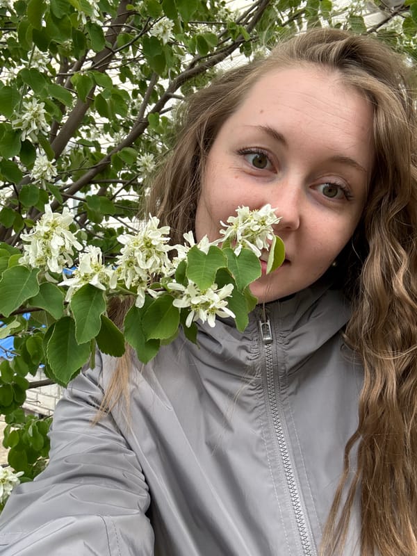 Woman photographed multiple times near flowering trees, unknown location
