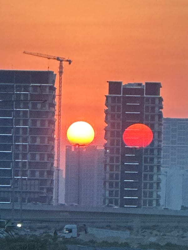 Dubai sunset over construction skyline, with a gym stop