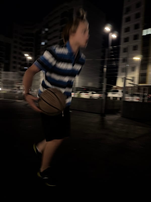 Late-night basketball on a wet outdoor court in Izhevsk