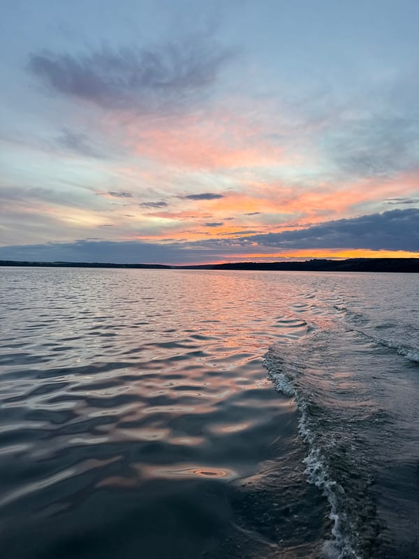 Boat wake and a vivid sunset over a Votkinsk lake