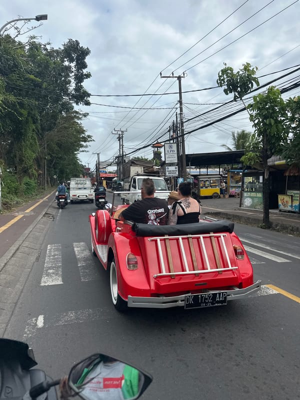 Red convertible cruising through cloudy Kuta Selatan streets