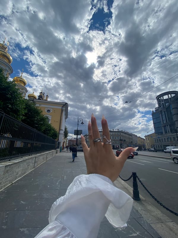 Selfie session on a Saint Petersburg sidewalk, summer morning