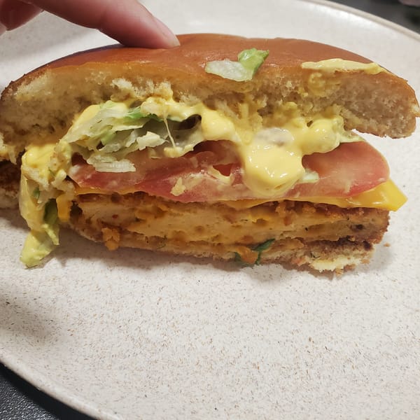 Half-eaten sandwich documented on plate in Curitiba