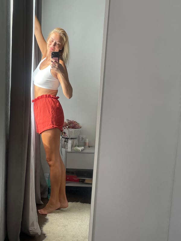 Woman photographs herself in bedroom during early morning session