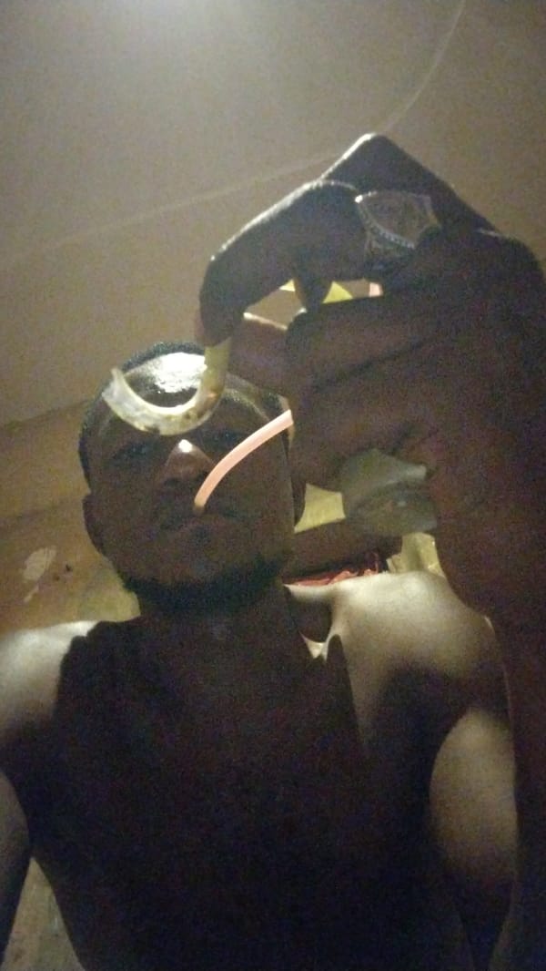Individual documented consuming substances in dimly lit indoor location