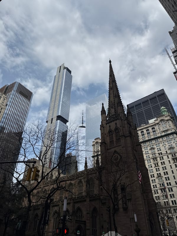 NYC skyscrapers and Trinity Church photographed under cloudy skies