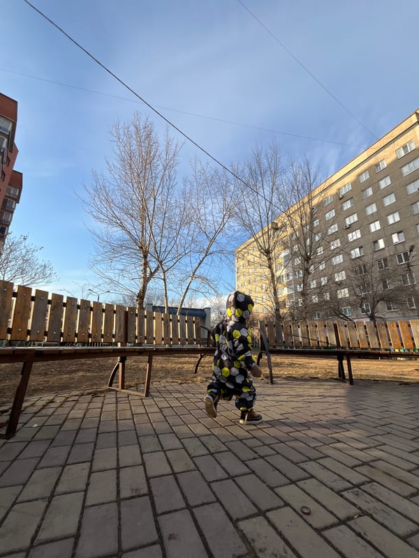 Person photographed on park bench in Krasnoyarsk urban setting