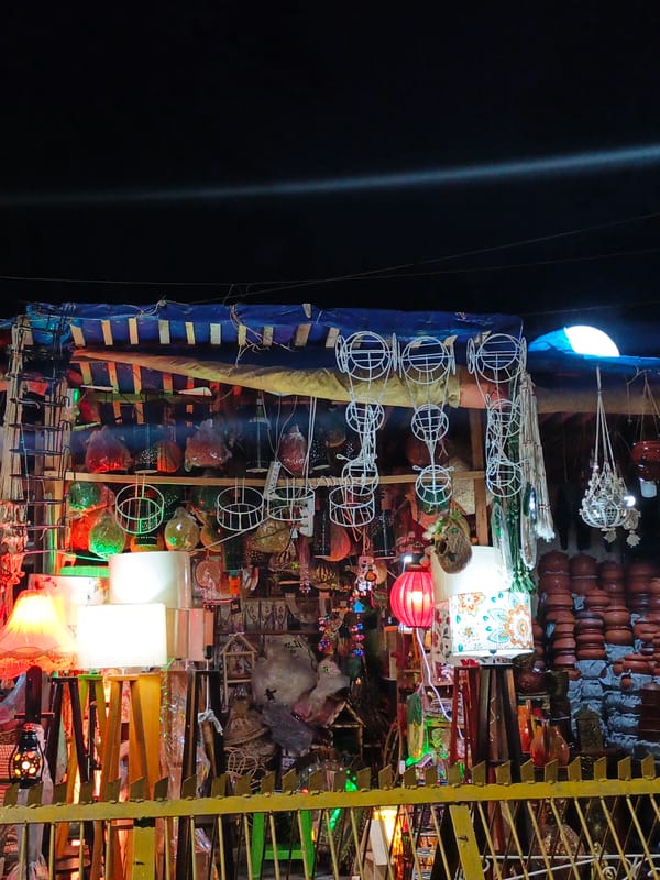 Night market with lamp stall, parked motorcycles observed