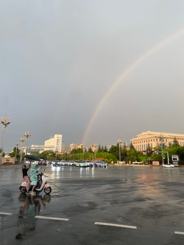 Rainbow over wet streets in Xishan District after summer rain