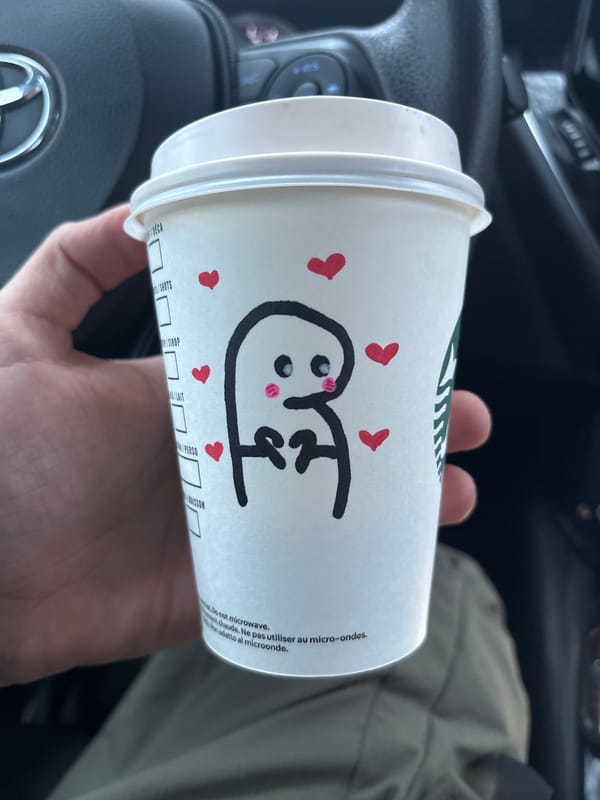 Customer holds decorated Starbucks cup with cartoon heart design