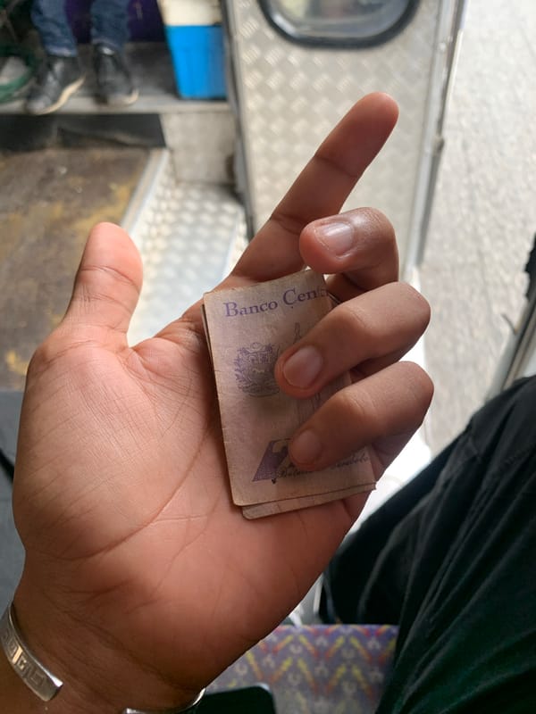 Person handles cash during vehicle journey in La Asuncion