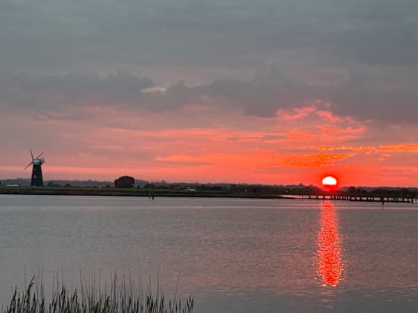 Sunset wetlands with windmill captured near Great Yarmouth