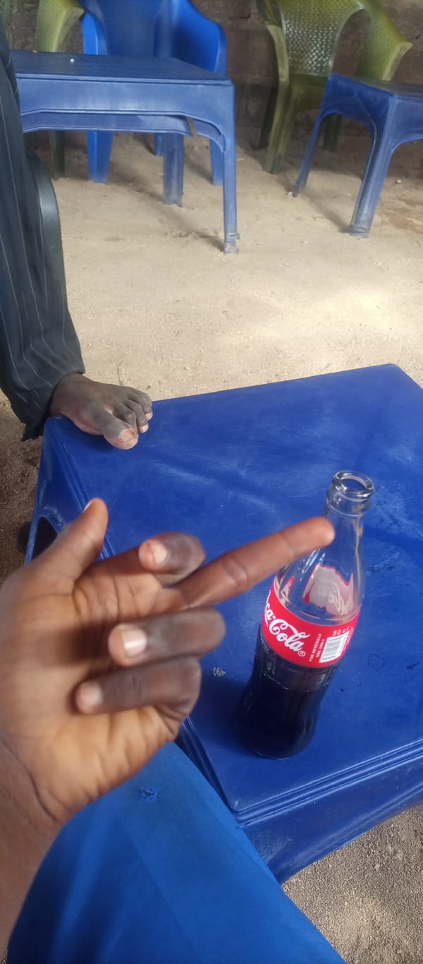 Afternoon hangout at a Jalingo open-air spot, Coke in hand