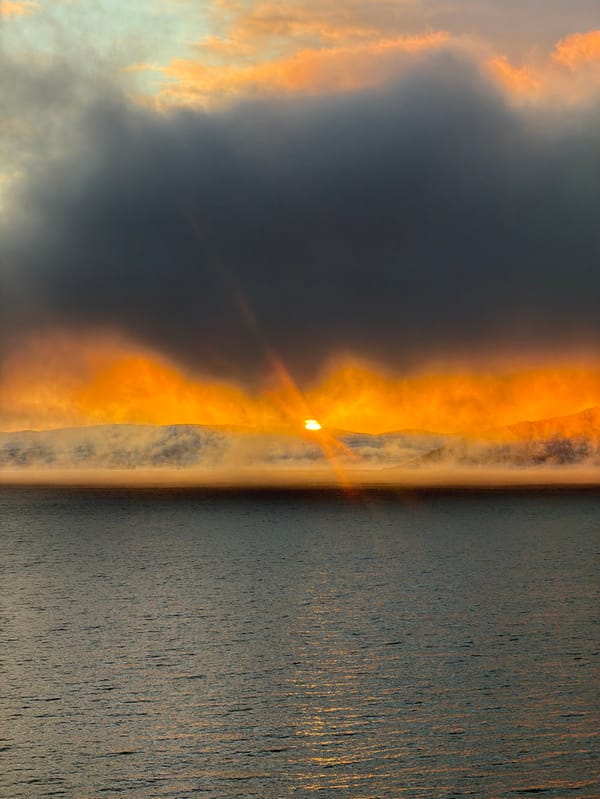 Dramatic sunrise illuminates fjord landscape near Tromsø, Norway
