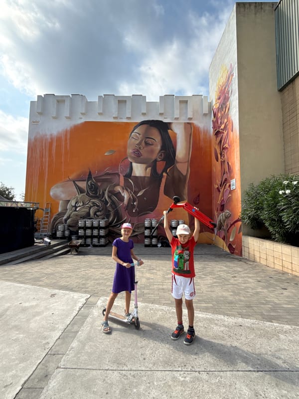 Street mural and scooters in a Blanes plaza