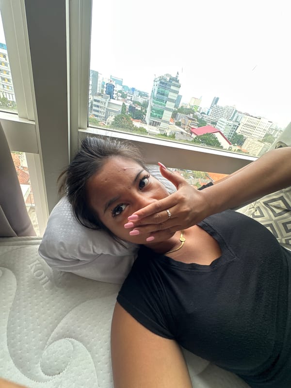 Woman films from high-rise window overlooking Central Jakarta skyline