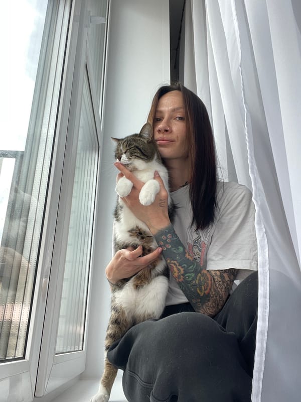 Tattooed woman and tabby cat share quiet morning moments