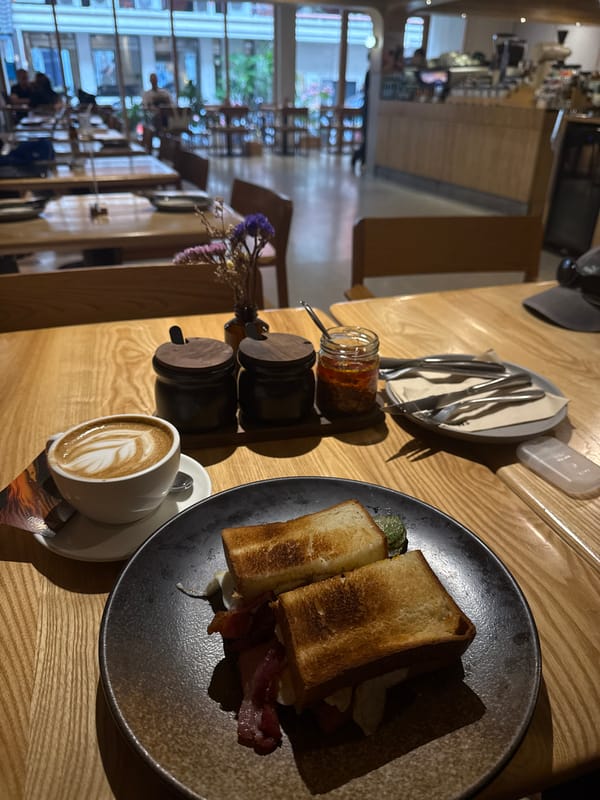 Bacon sandwich and latte at a Bangkok café table