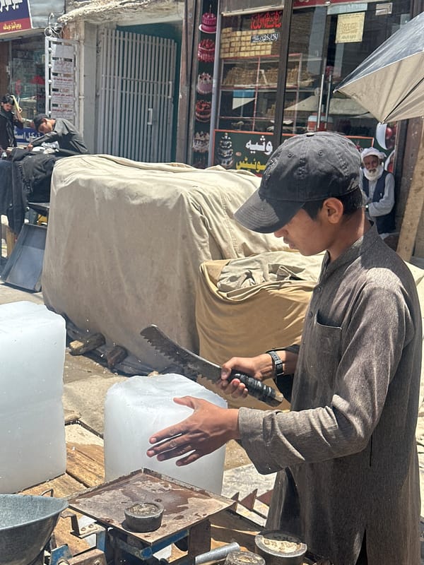Man cuts ice block on busy Pishin street