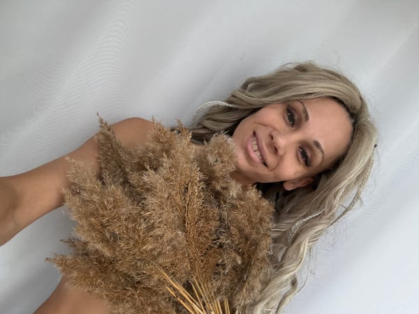 Woman poses with pampas grass in early morning photoshoot