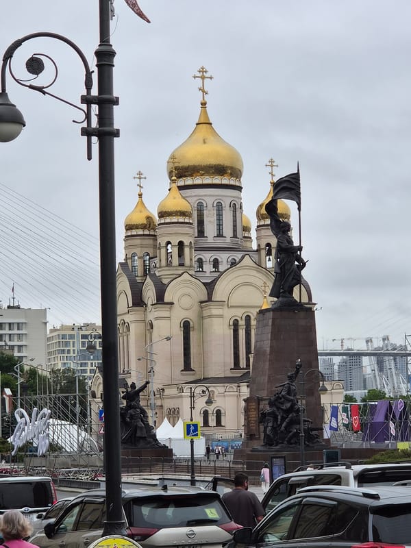 Svetlanskaya Street in full swing: flowers, traffic, and architecture