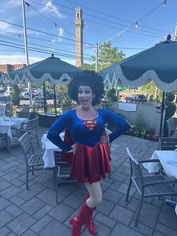Superman costume at a patio table, outdoors