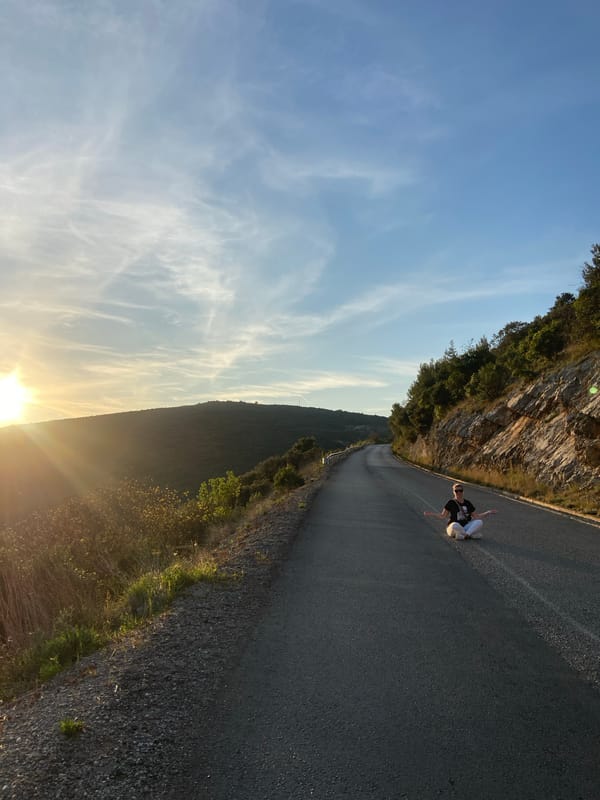 Person sits on mountain road in Višnjevo, Montenegro