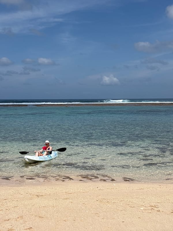 Clear morning at a Kuta Selatan beach with surf and kayaking