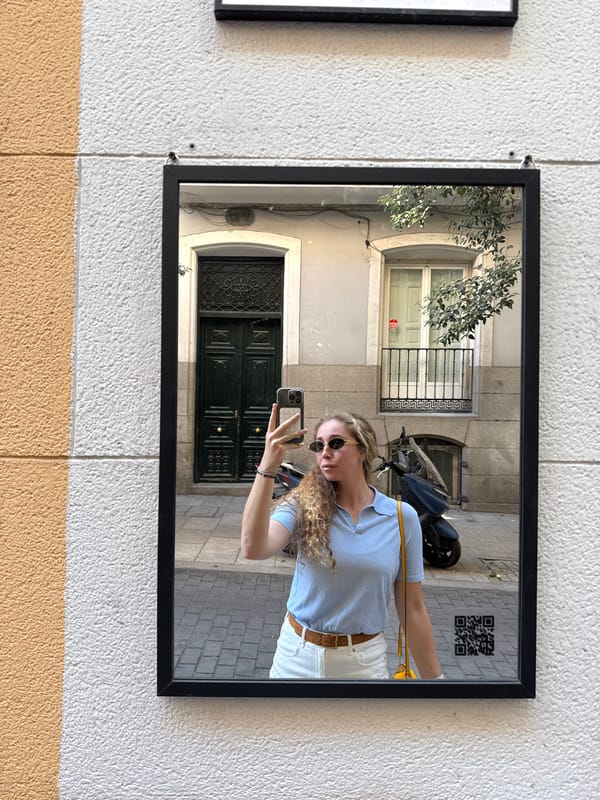 Woman photographed through street mirror reflection in Madrid