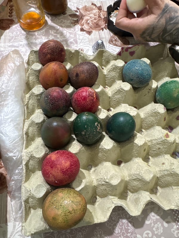 Easter eggs arranged in carton on floral tablecloth