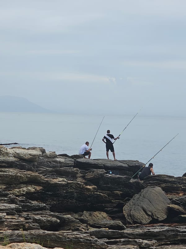 Woman meditates on rock formation in Brazilian coastal town