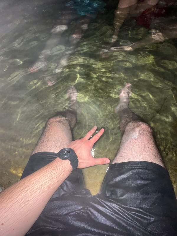 Person wades in clear water near Medousa, Greece