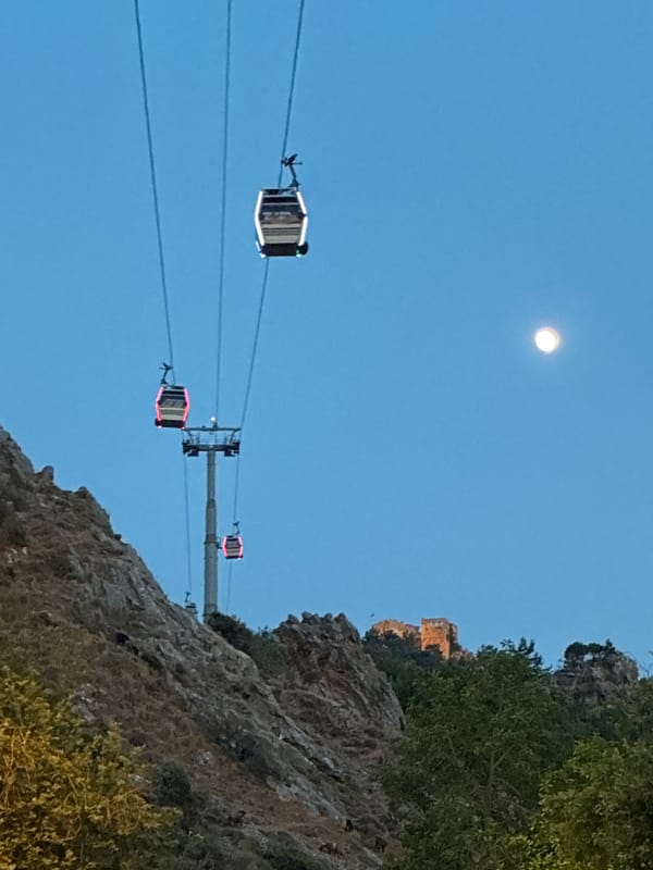 Cable cars and fairy lights at dusk in Alanya