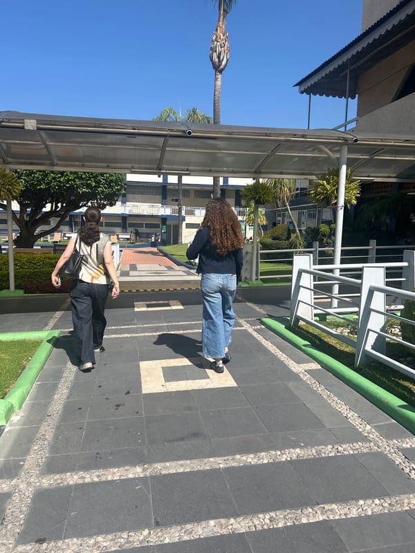 Two people walk near urban pool area