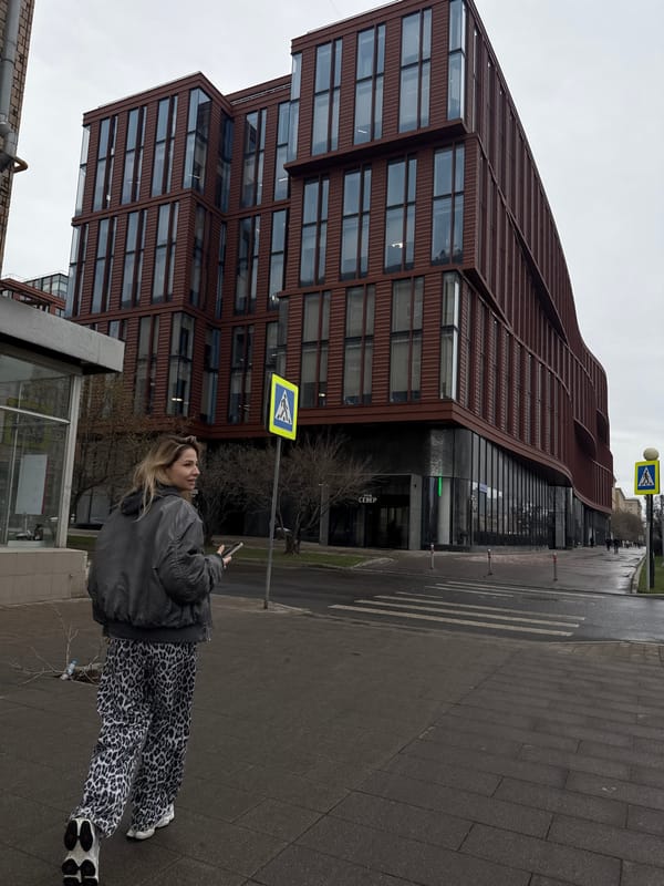 Woman checks phone on Moscow street near ornate building