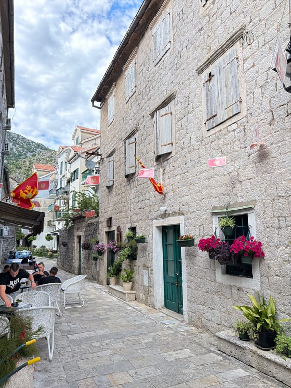 Tourist documents historic architecture and harbor in Risan, Montenegro