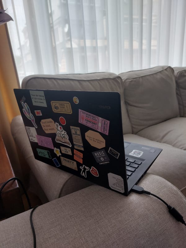 Sticker-covered laptop observed on couch in Plovdiv, Bulgaria