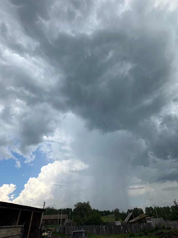 Storm building over a quiet rural village and garden