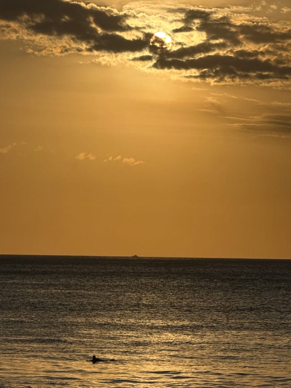 Sunset beach session: surfers, waves, and a juggler on the sand