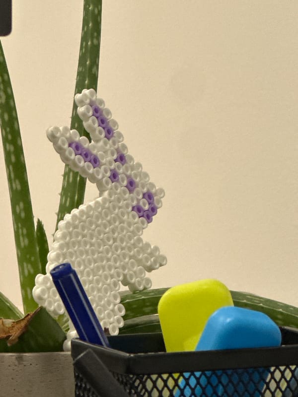Handcrafted beaded figure spotted on plant with blue marker