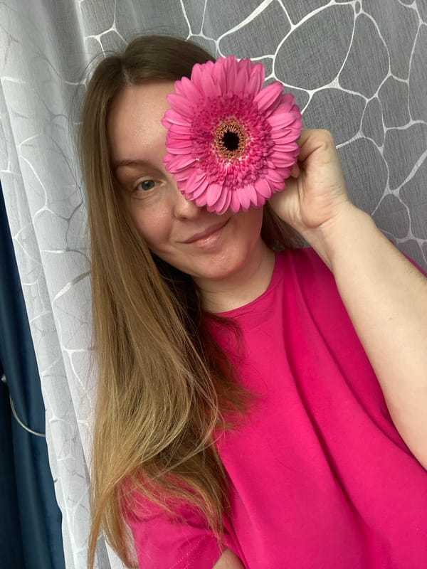 Woman poses with pink gerbera daisy in Noviy photo session
